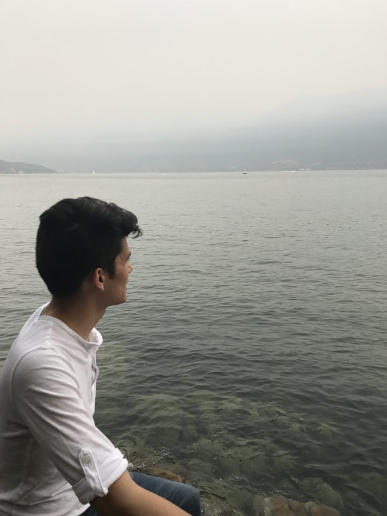 Cameron sitting on a rock at the shore of Vancouver Island, Canada.