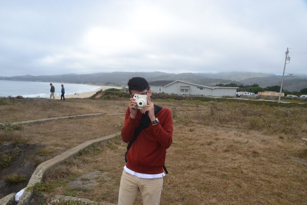 Cameron holding a camera in Half Moon Bay.