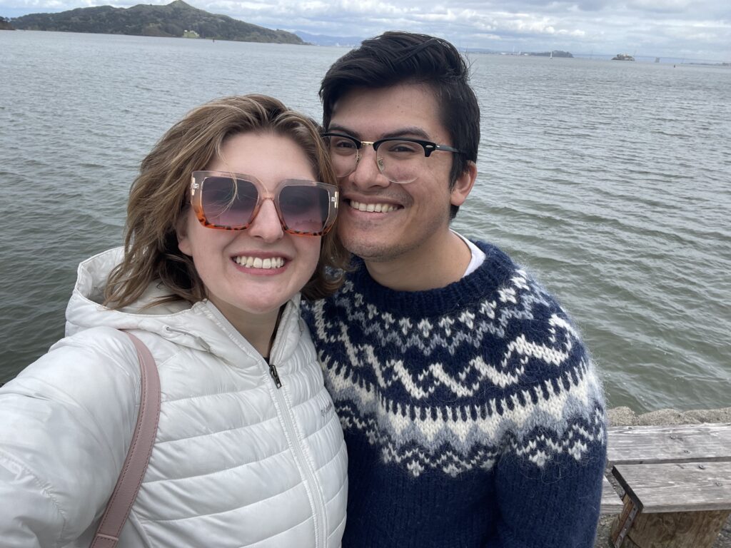 A photo of Cameron along with his girlfriend in front of the ocean.